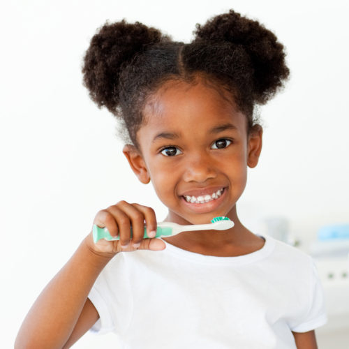 Portrait of an Afro-american girl brushing her teeth